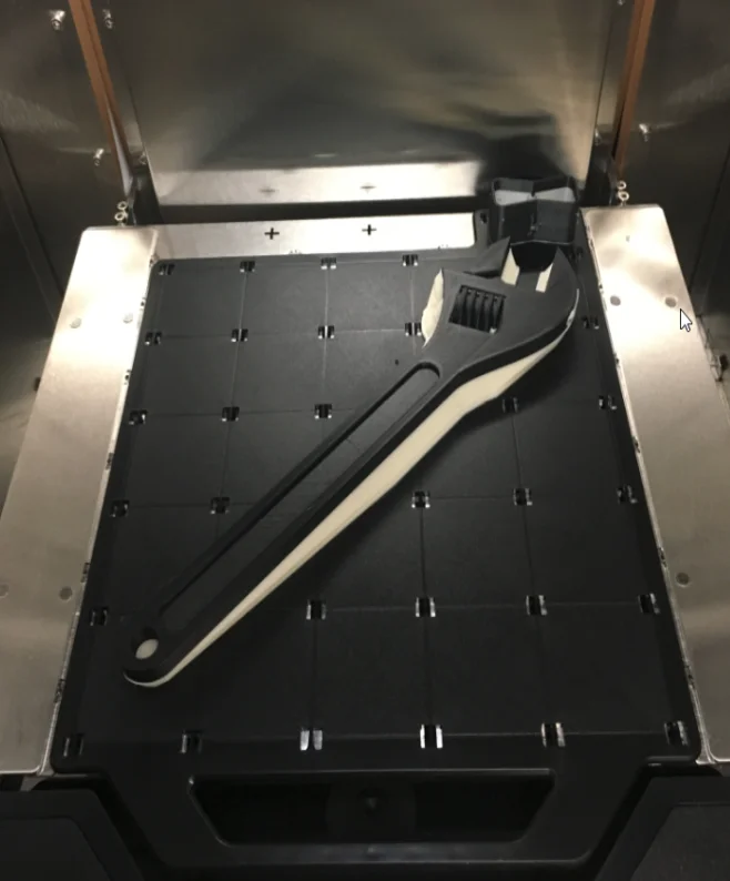 3D printed adjustable wrench with support material still attached to model material. - Fictiv 3D printed adjustable wrench with support material still attached to model material.