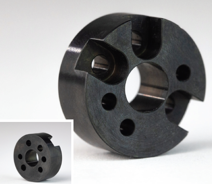 A circular metal part with holes drilled in it, finished using black oxide