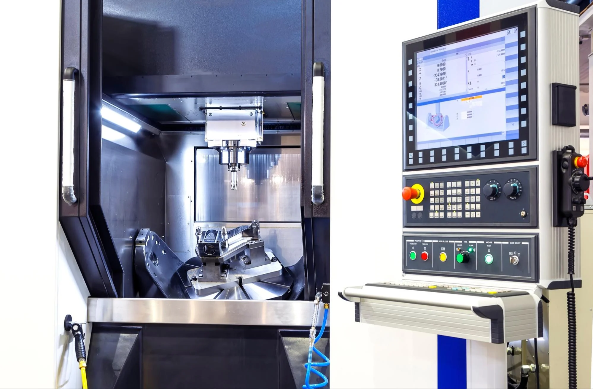 a 5 axis cnc machine with the door open and the code loaded on the display screen