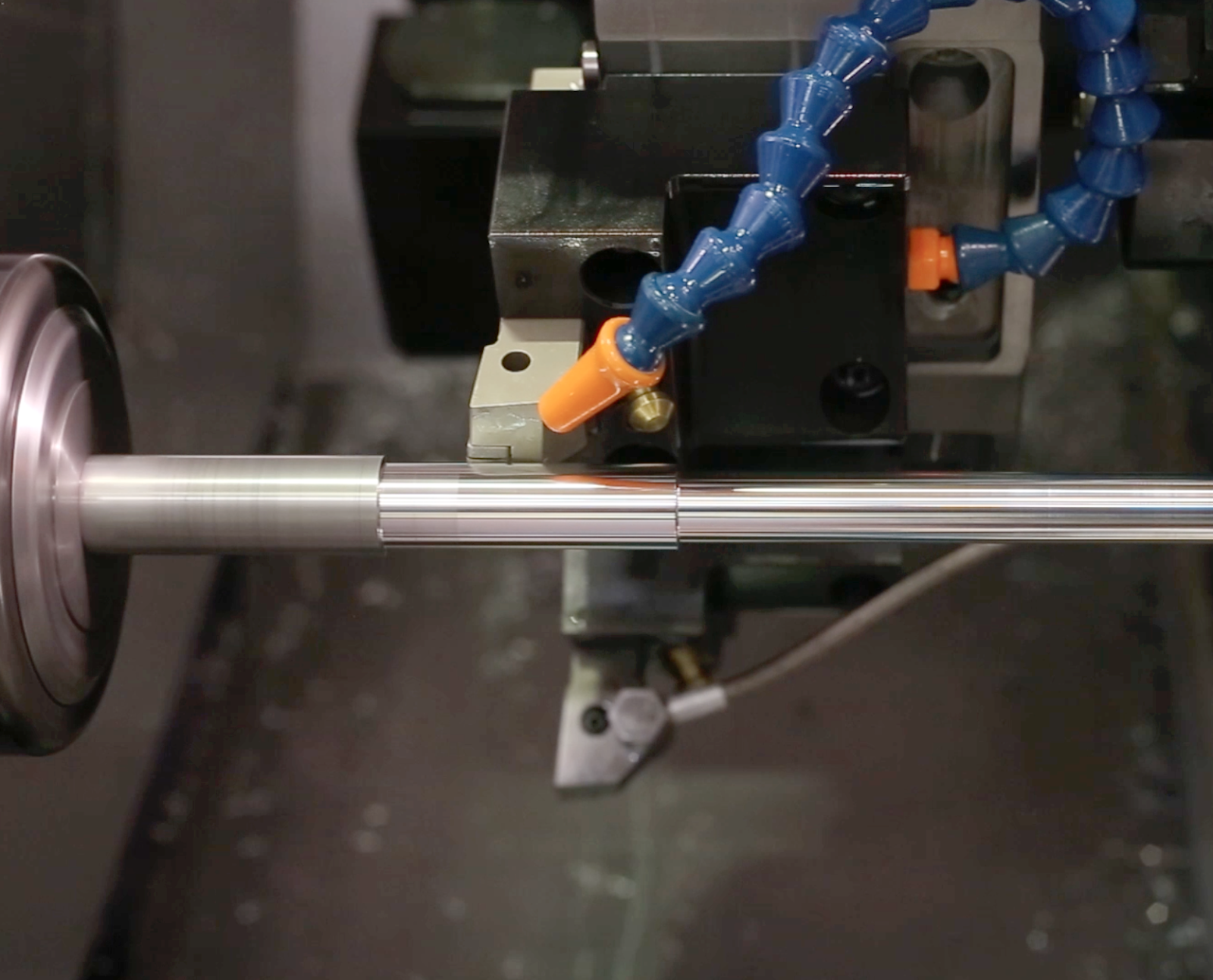 turning (1) - Fictiv metal rod being turned on a lathe with air coolant feed