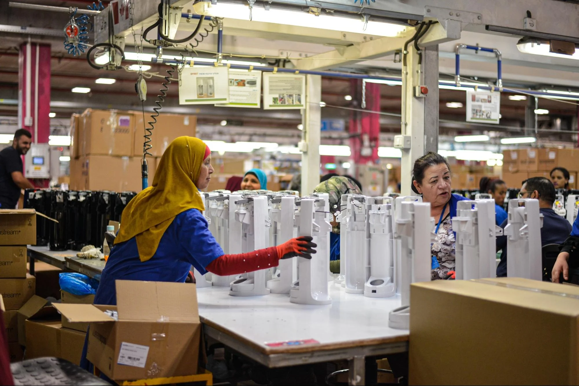 assembly line - Fictiv woman holding parts on an assembly line