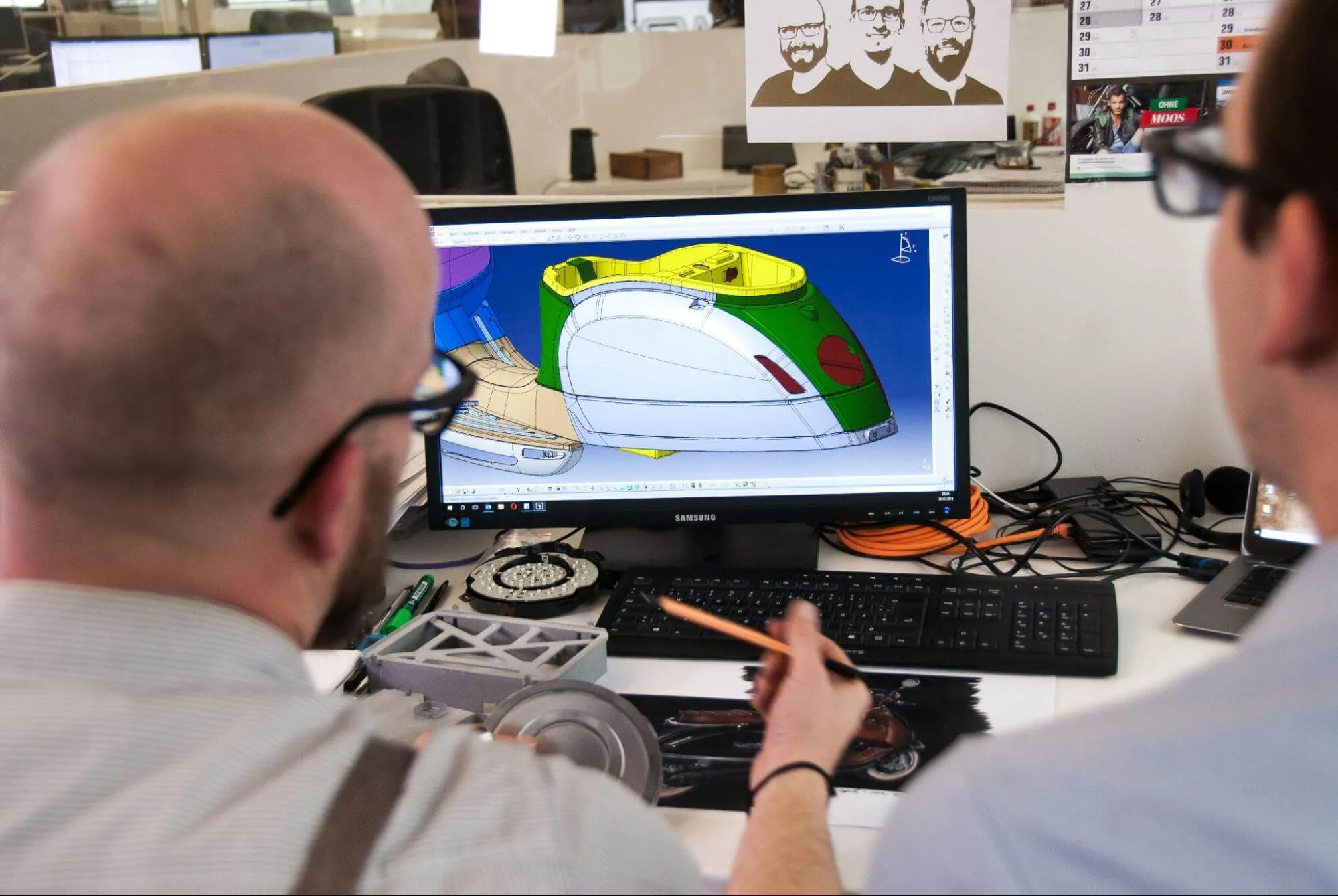 CAD - Fictiv engineers sitting at computer with CAD discussing machining tolerances