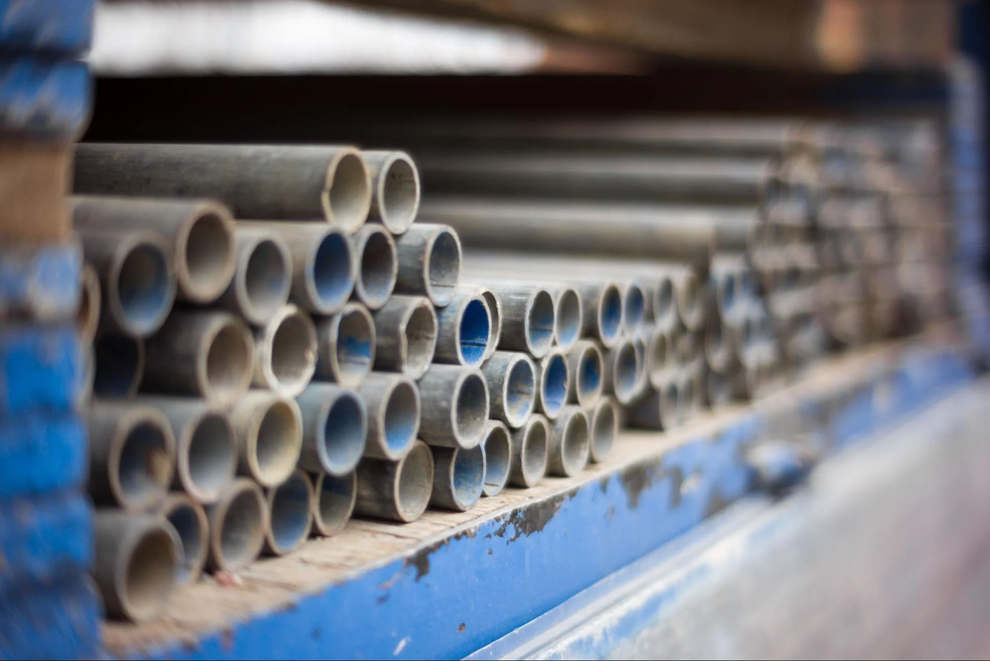 steel tubing - Fictiv round steel tubes stacked on shelf
