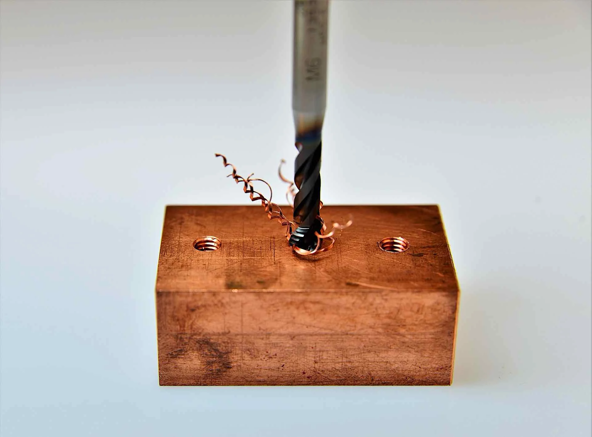 fictiv1taps-3211476_1920 - Fictiv Image of a block of copper being tapped with threaded holes