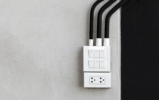 White Light Switch and Outlet on Panorama Concrete Wall