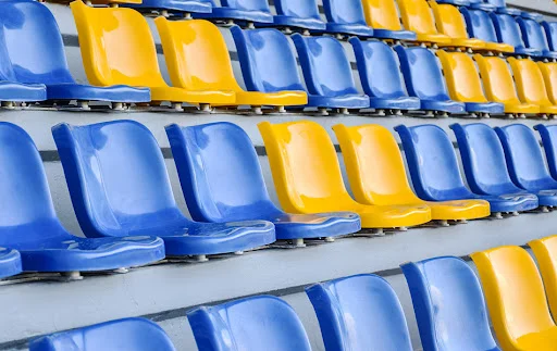 plastic-seats-in-arena - Fictiv blue and yellow plastic seats in an arena