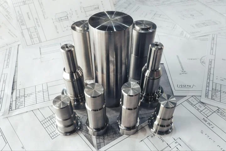 CNC-turned parts atop engineering drawings