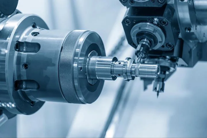 CNC turn-mill machine cutting groove at the metal shaft