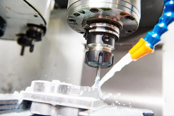 Coolant being sprayed on a part - Fictiv Coolant being sprayed on a part during CNC machining