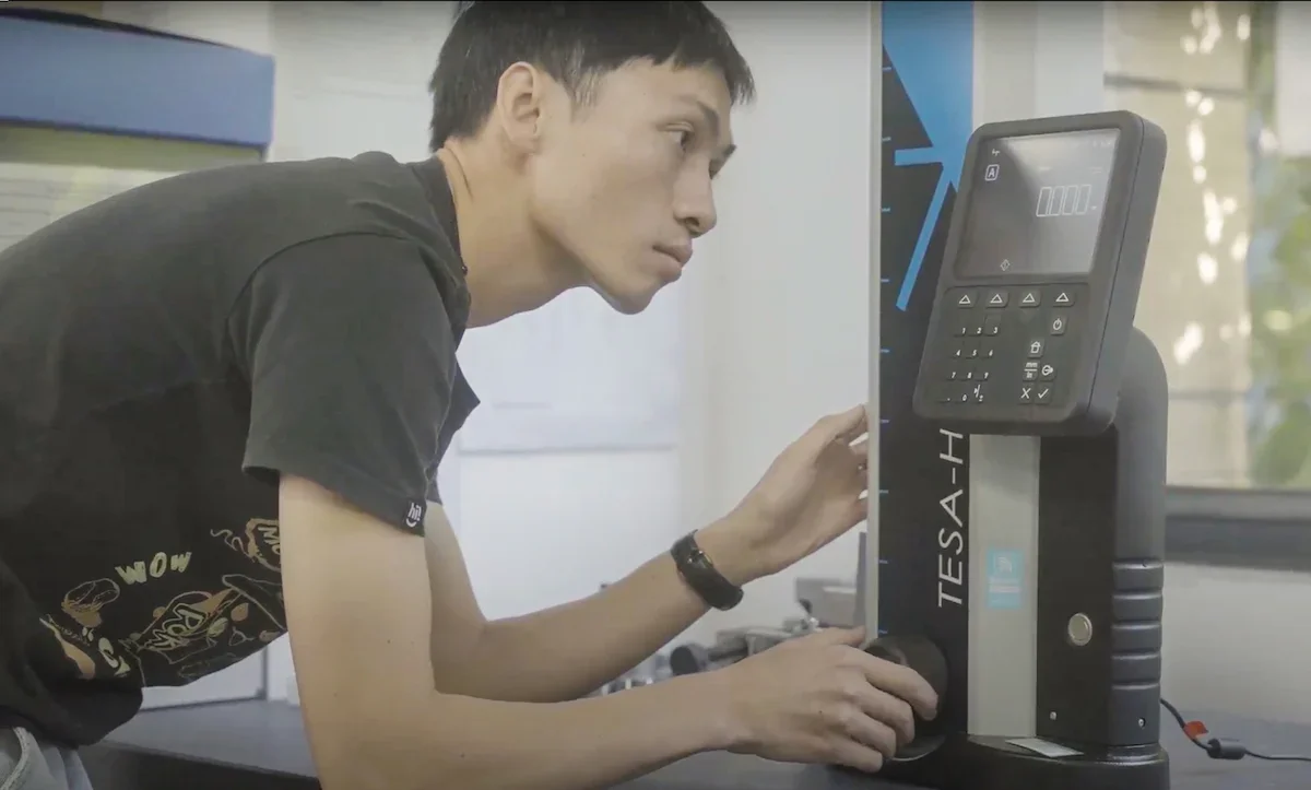 A Fictiv quality control inspector measures the height of a boss for a injection molded consumer products part. - Fictiv A Fictiv quality control inspector measures the height of a boss for a injection molded consumer products part.