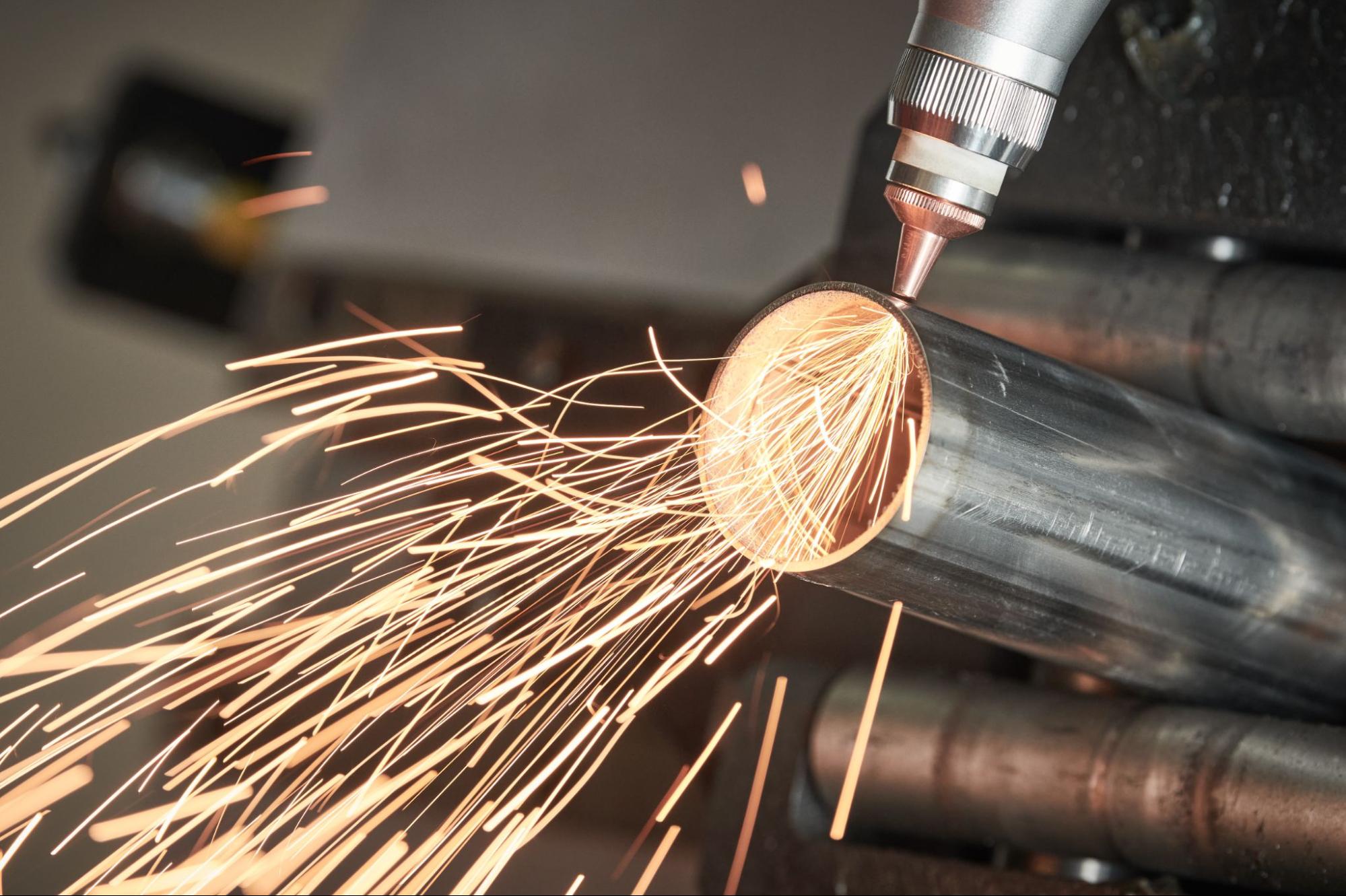 Fiber laser cutting a round metal pipe.
