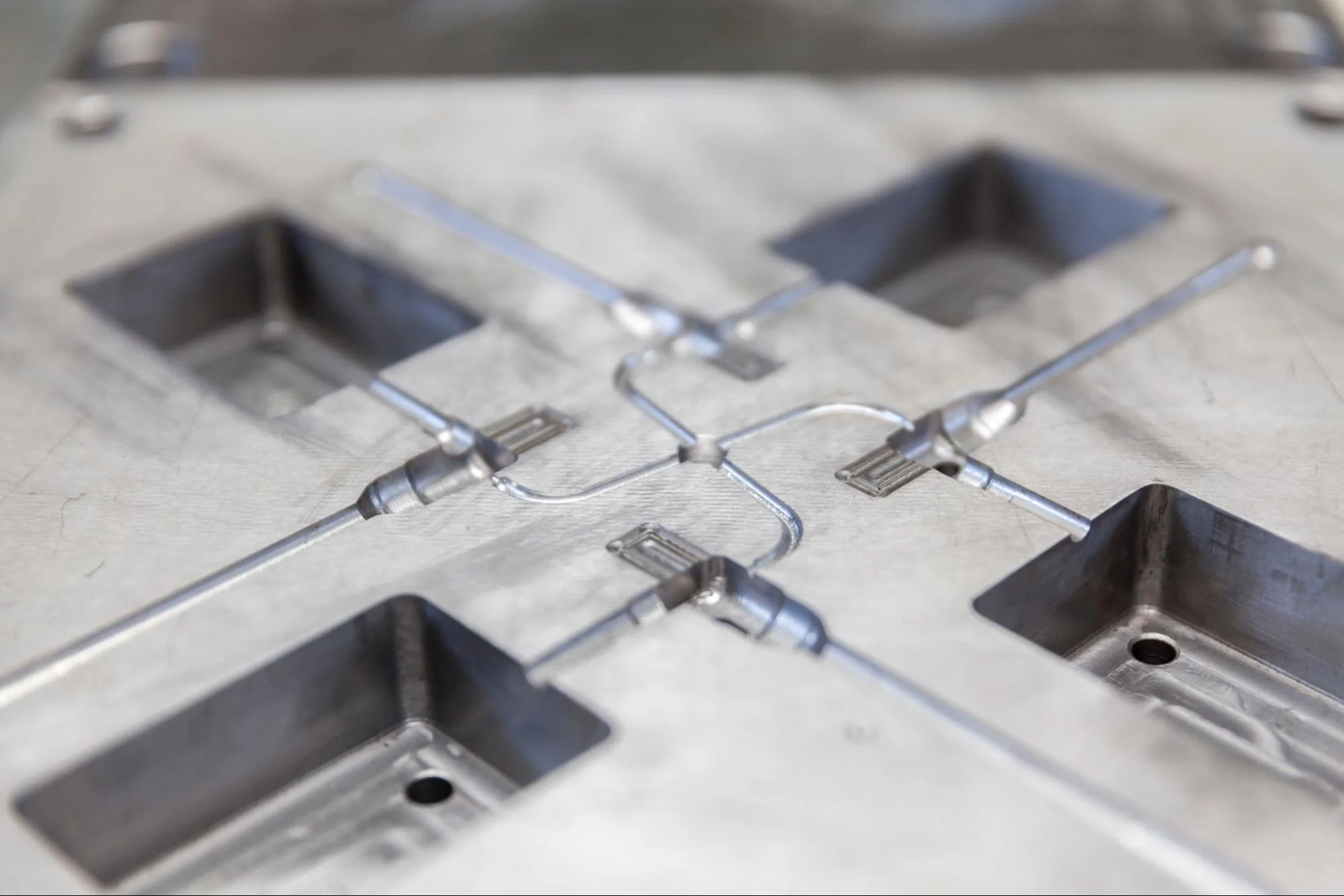 Gate and runners for a 4-cavity injection mold tool.