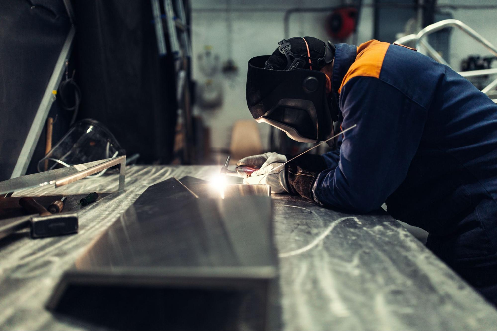 A factory worker creates a spot weld on a sheet metal weldment.
