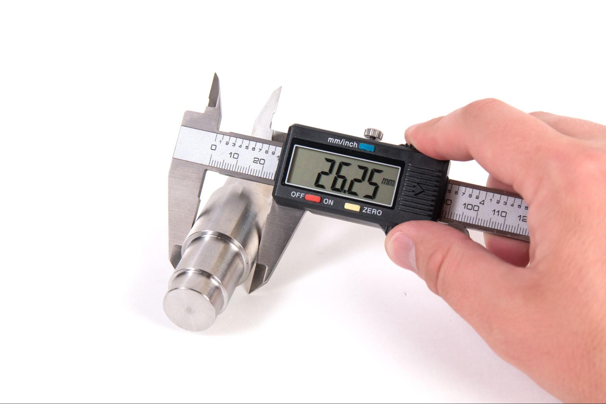 Calipers being used to measure a tight tolerance shaft diameter