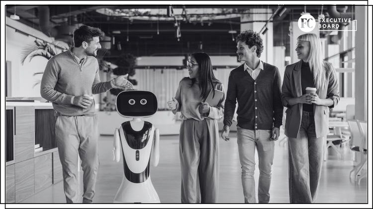 Four professionals chat with a friendly humanoid robot in a modern open-office lobby; Executive Board logo visible in the corner.