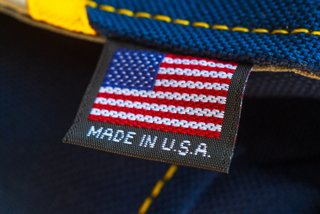 Close-up of a clothing tag with an American flag and 'MADE IN U.S.A.' on blue fabric edge.