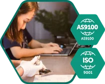 icon-quality - Fictiv Person at a desk using a laptop, with teal AS9100 and ISO 9001 certification badges in the foregrounds.