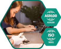 icon-quality - Fictiv Person at a desk using a laptop, with teal AS9100 and ISO 9001 certification badges in the foregrounds.