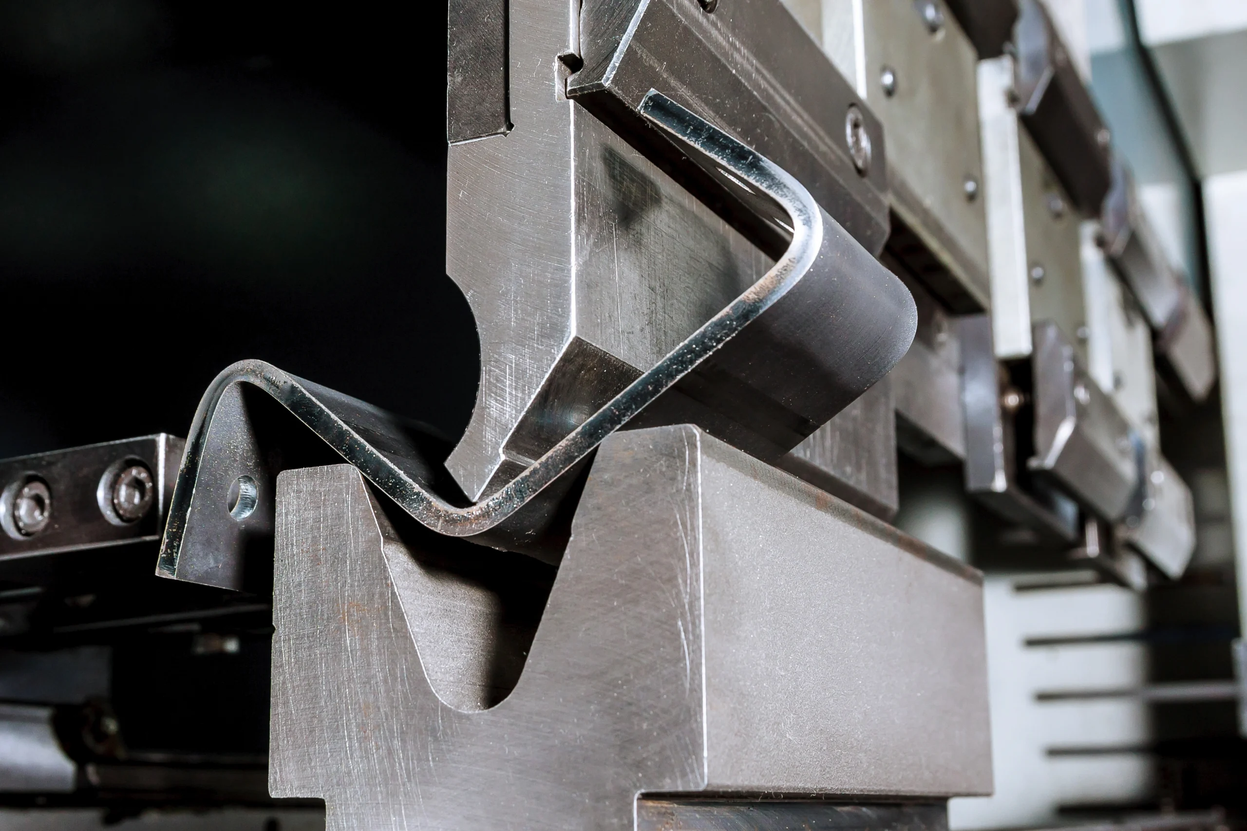 Close-up of steel machine blocks, brackets, and bolts in an industrial metalworking fixture.