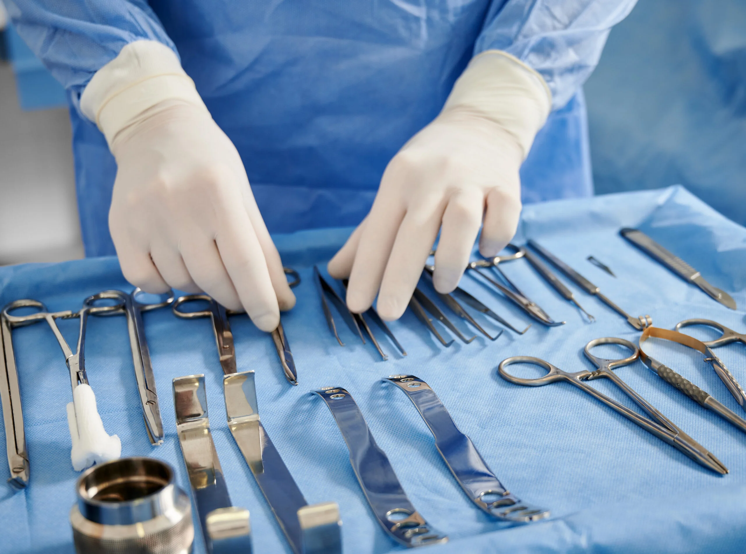 Doctor preparing instruments for plastic surgery in operating room - Fictiv Machined metal surgical instruments